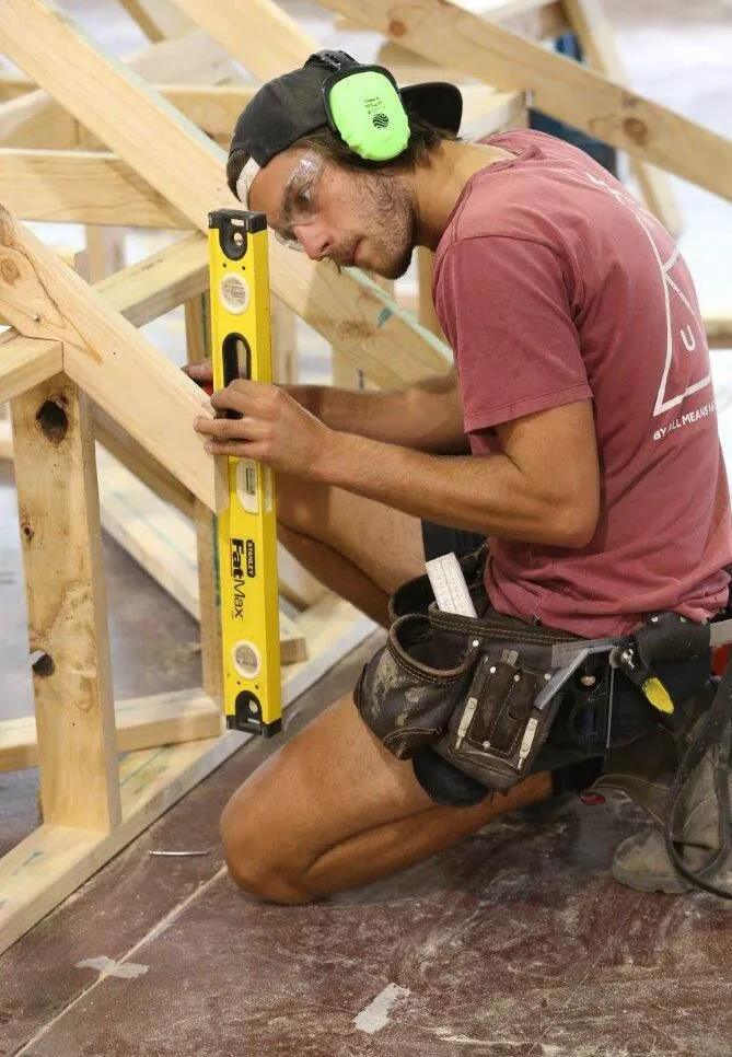 Disability DIAP MEGT young man carpenter carpentry protective ear coverings spirit level timber frame blue-collar worker carpenter clothing handyman man outdoor person tool