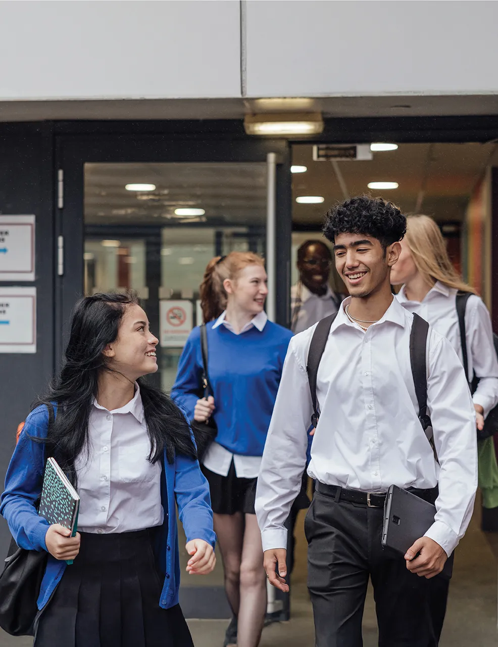 Two students walking away from school.