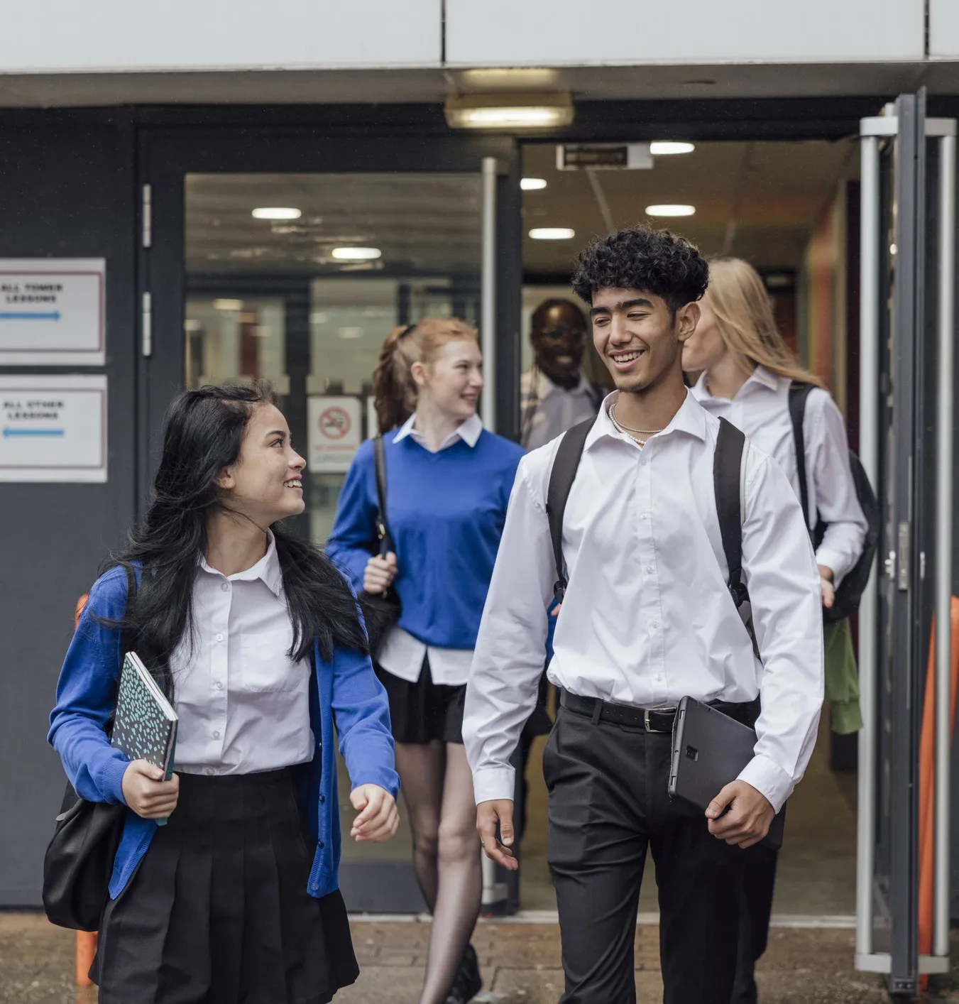 Two students walking away from school.